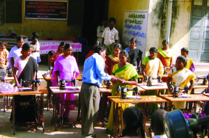 Photo of Sam Bandela presenting sewing machines to women in India courtesy CBF